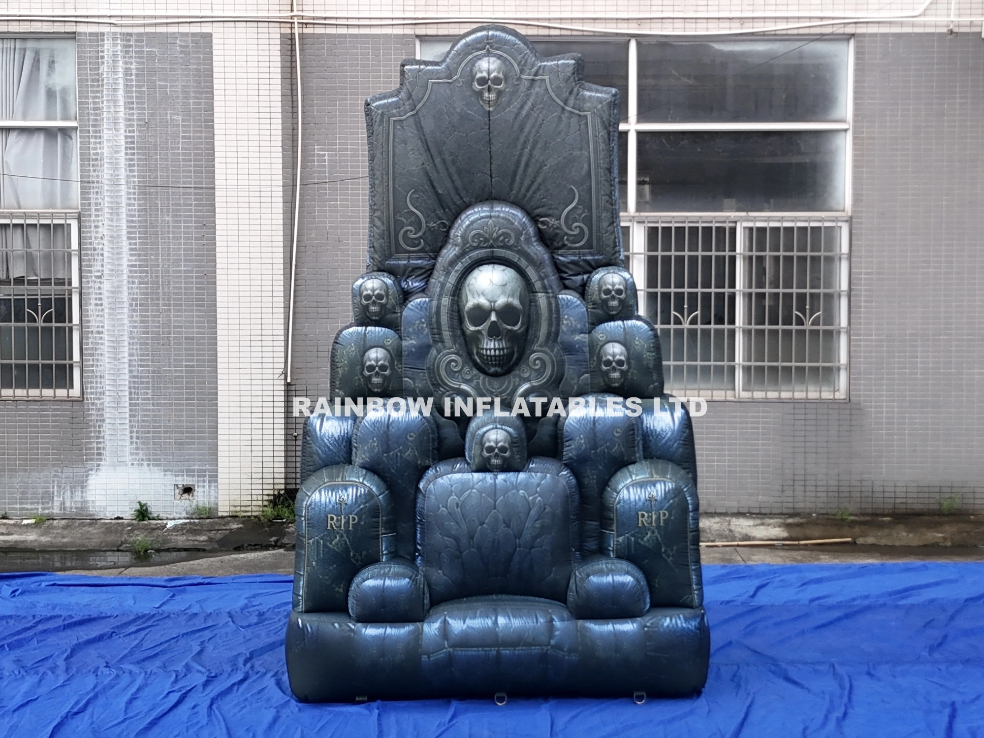 Giant inflatable Halloween skull throne with stone texture and RIP details